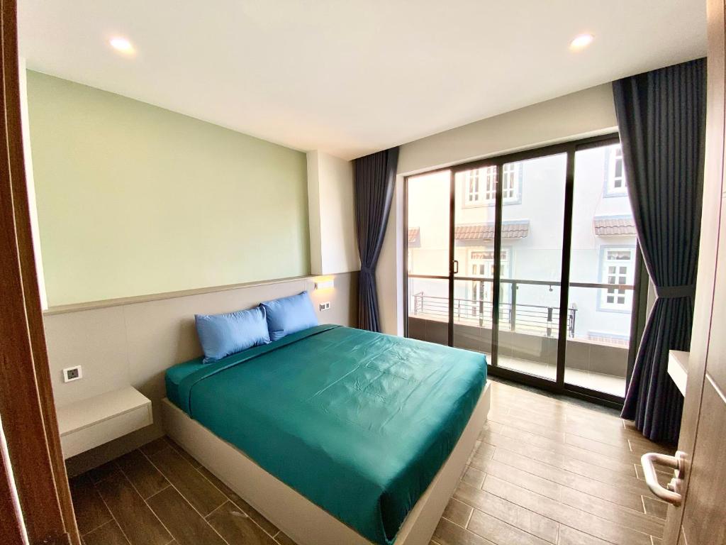 a bedroom with a bed and a large window at Kim Oanh Apartment in Da Lat