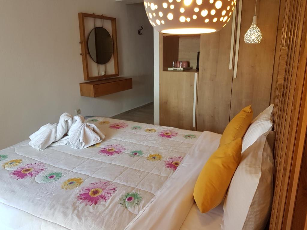 - une chambre avec un grand lit fleuri dans l'établissement Marina, à Nikiti