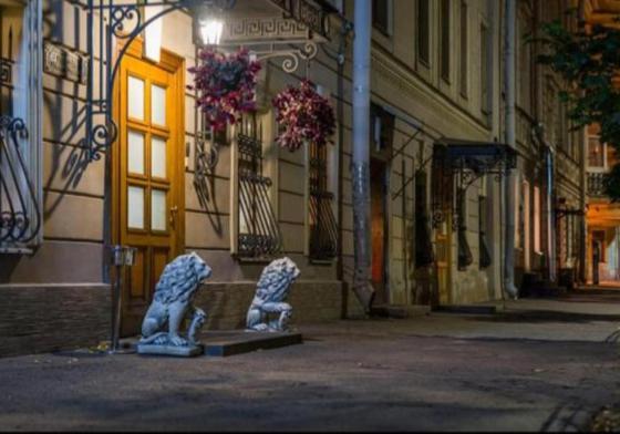 two blue chairs sitting in front of a building at Kamerdiner Hotel in Saint Petersburg