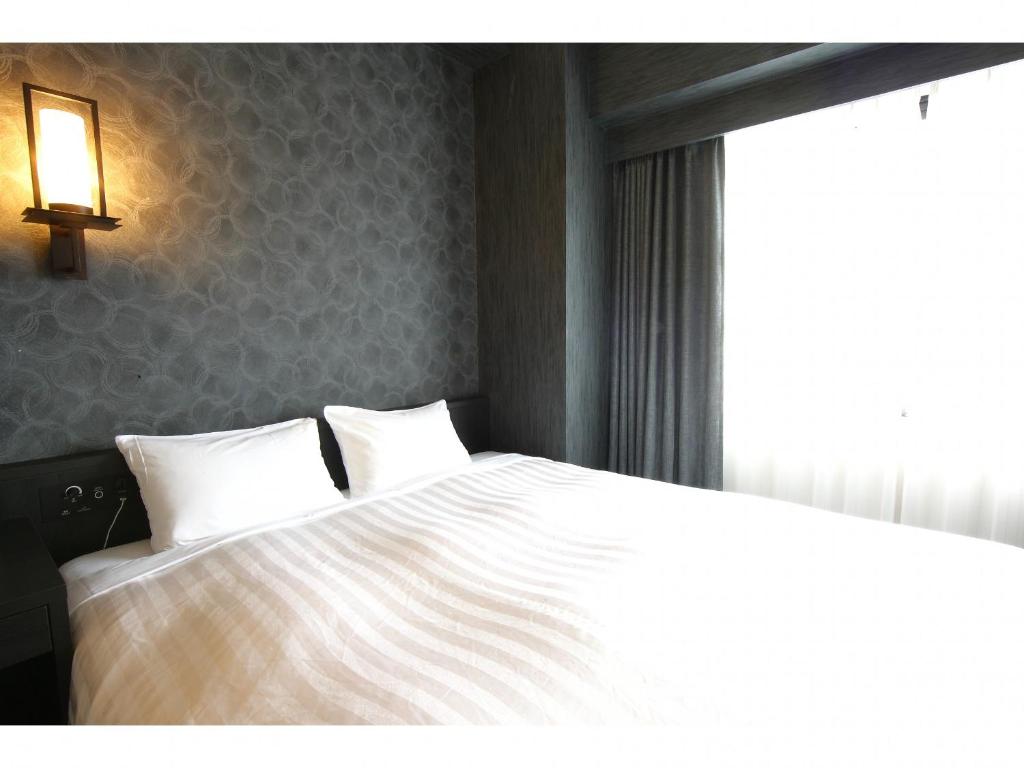 Postel nebo postele na pokoji v ubytování FP HOTELS South-Namba