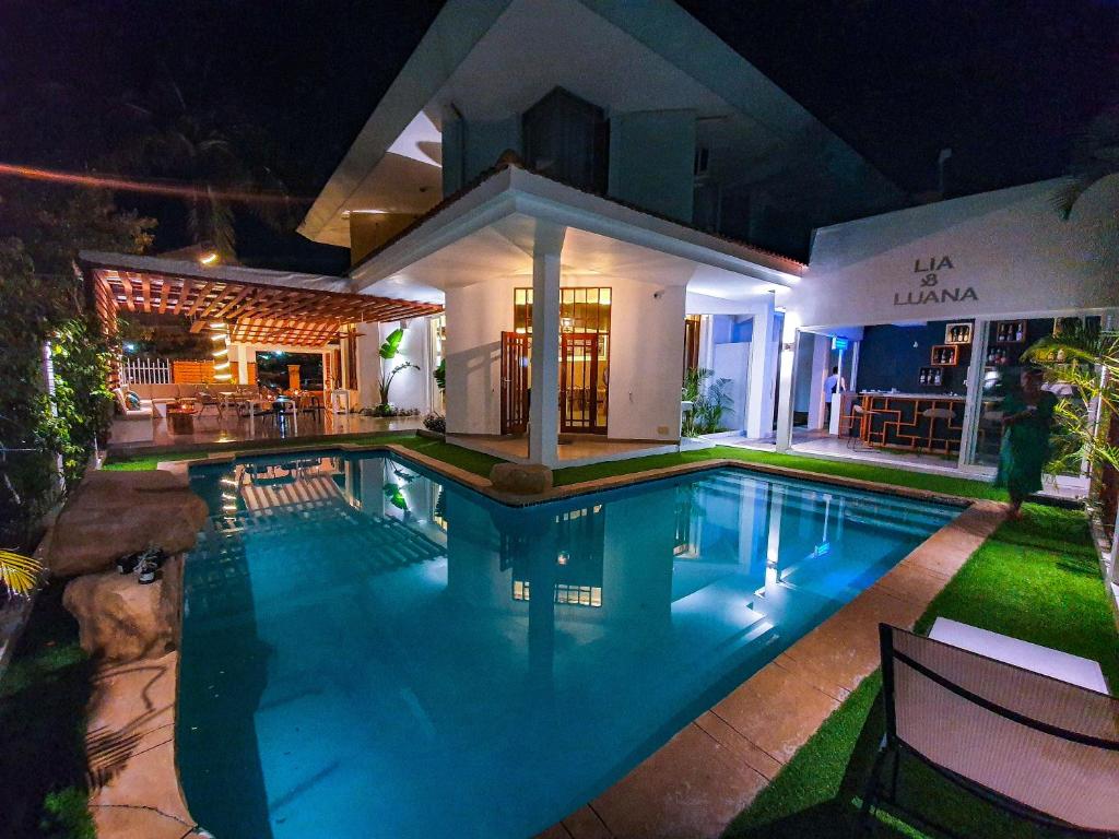 a swimming pool in front of a house at night at Angel Boutique Hotel in Maputo