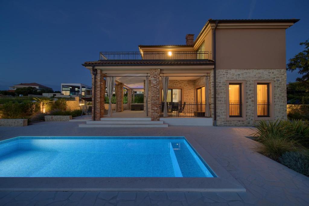 a house with a swimming pool in front of it at Villa Nathalie - Linardici, Krk in Linardići
