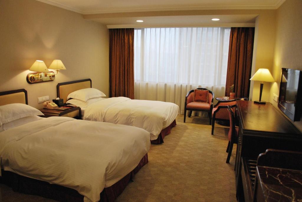 Postel nebo postele na pokoji v ubytování Zhongshan International Hotel