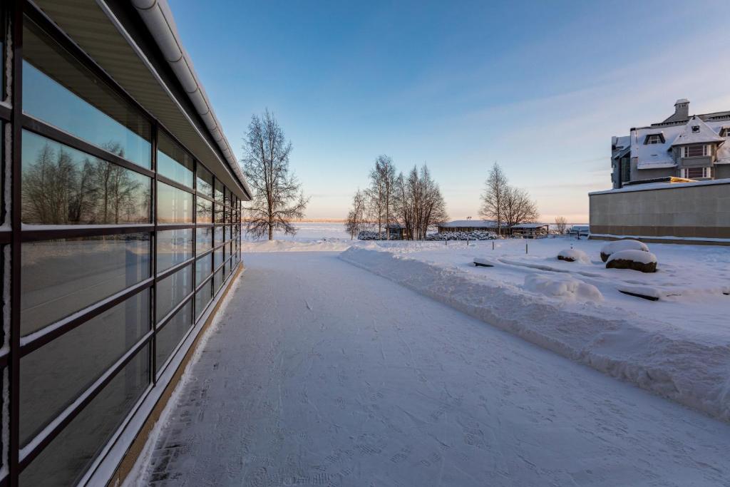 una acera cubierta de nieve junto a un edificio en Prionezhsky Club Hotel, en Petrozavodsk