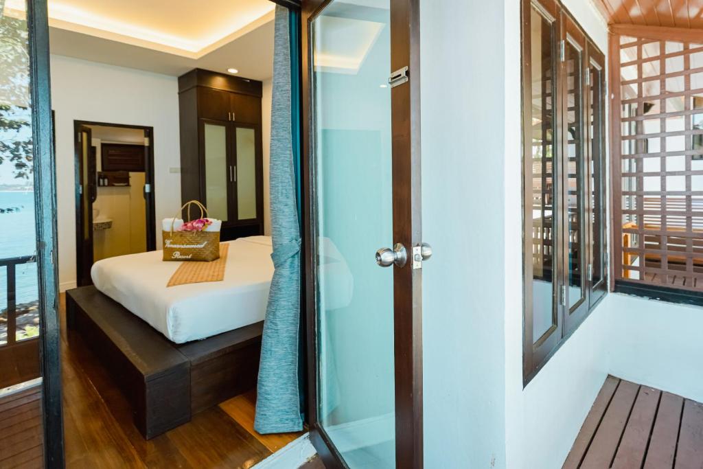 a bedroom with a bed and a glass door at Vimarn Samed Resort in Ko Samed