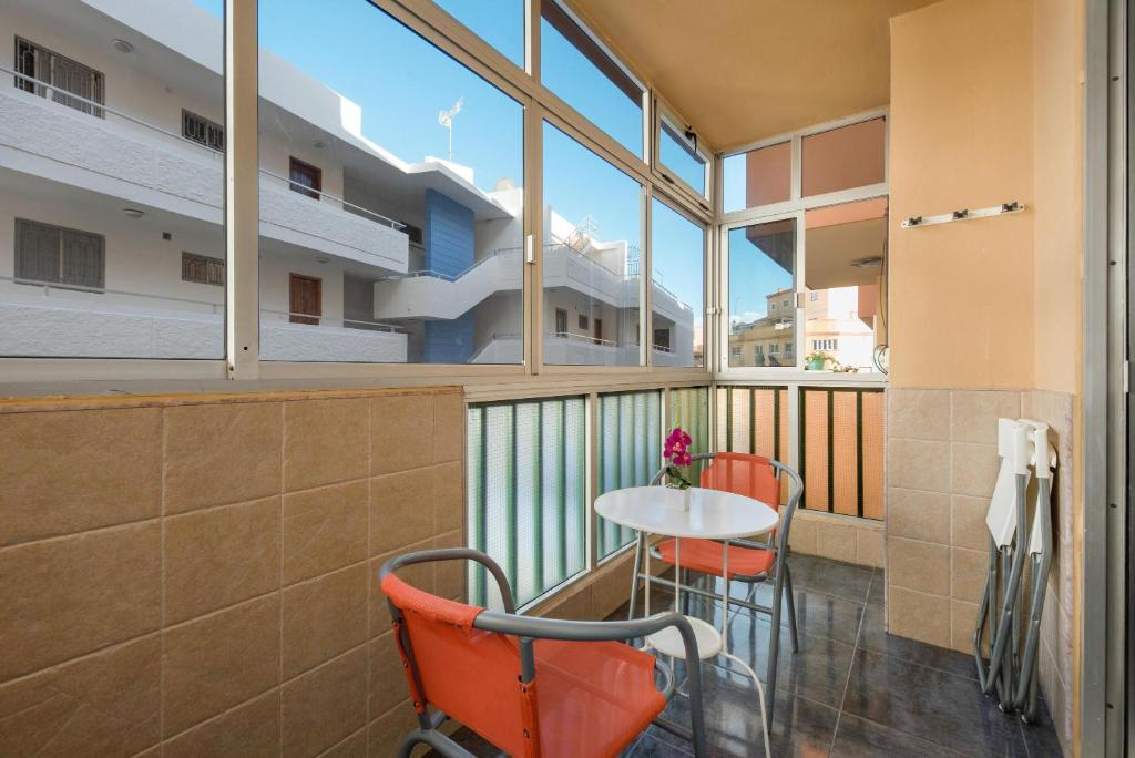 a balcony with a table and chairs and windows at Casa Caletillas in Candelaria