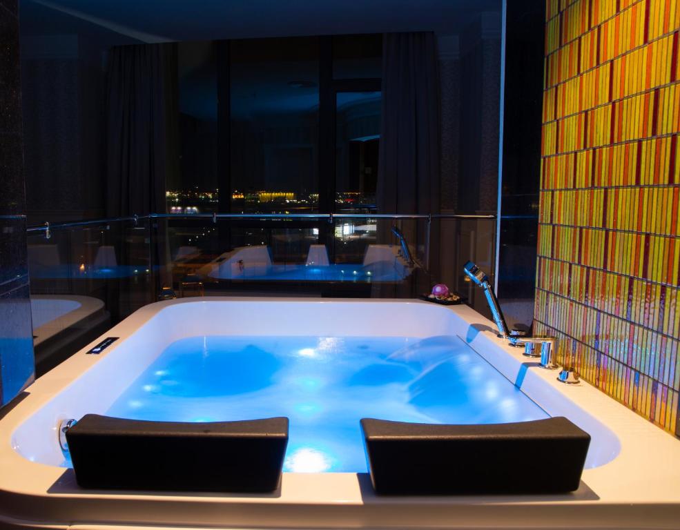 a jacuzzi tub in a room with a view at Aswar Boutique Hotel in Al Khobar