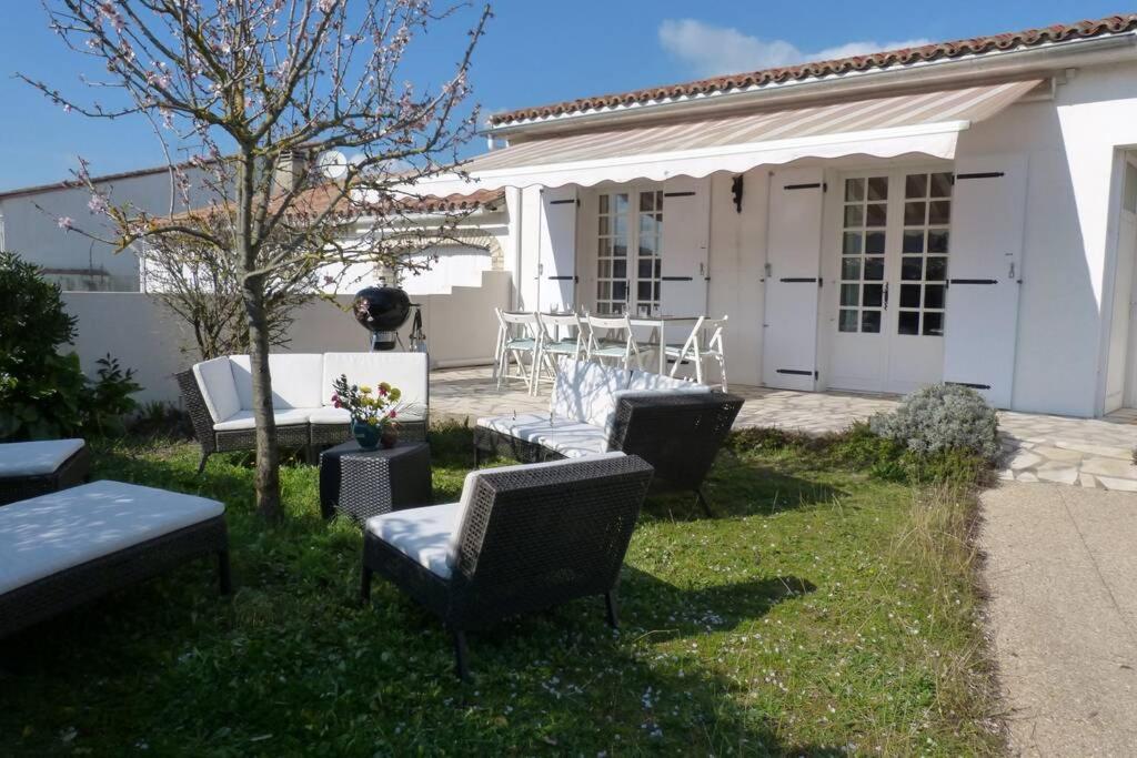 d'une terrasse avec des chaises et une table dans la cour. dans l'établissement MAISON 120m2 près centre et plages classée ***, au Bois-Plage-en-Ré