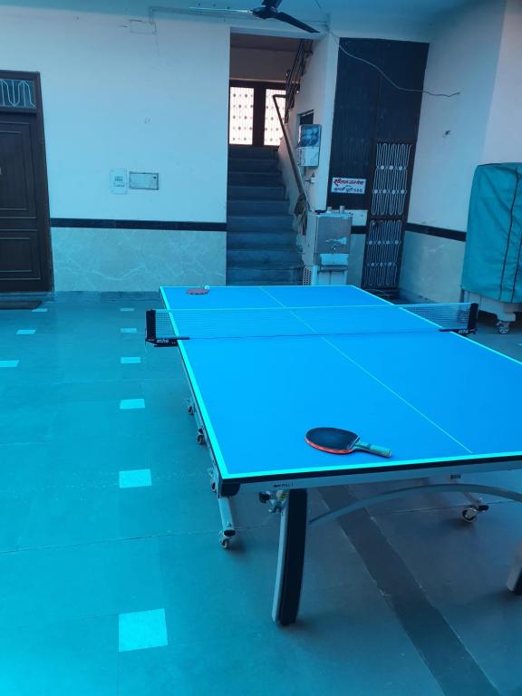 a blue ping pong table in a room with stairs at Shri Gaya Prasad Dham in Vrindāvan