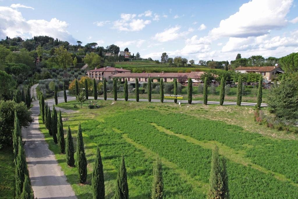 un parc avec des cyprès et une route dans l'établissement Hotel Sovestro, à San Gimignano