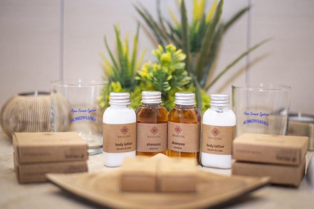 Assorted mini toiletries and boxed soaps displayed on counter with decorative plant behind.