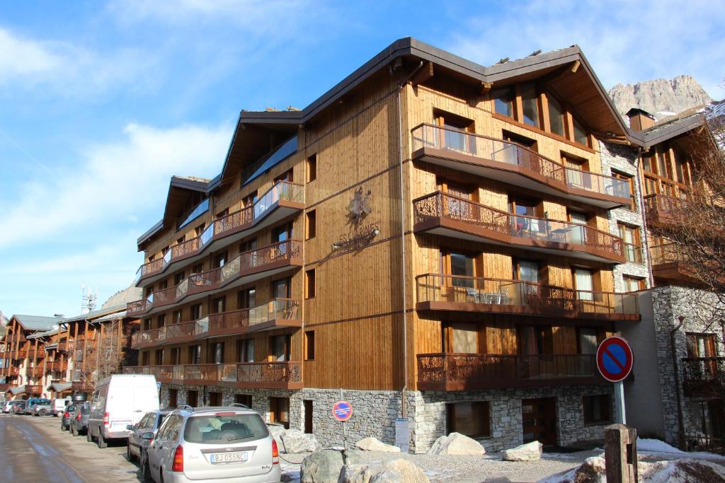 a tall building with cars parked in front of it at Les Clarines in Val-d'Isère