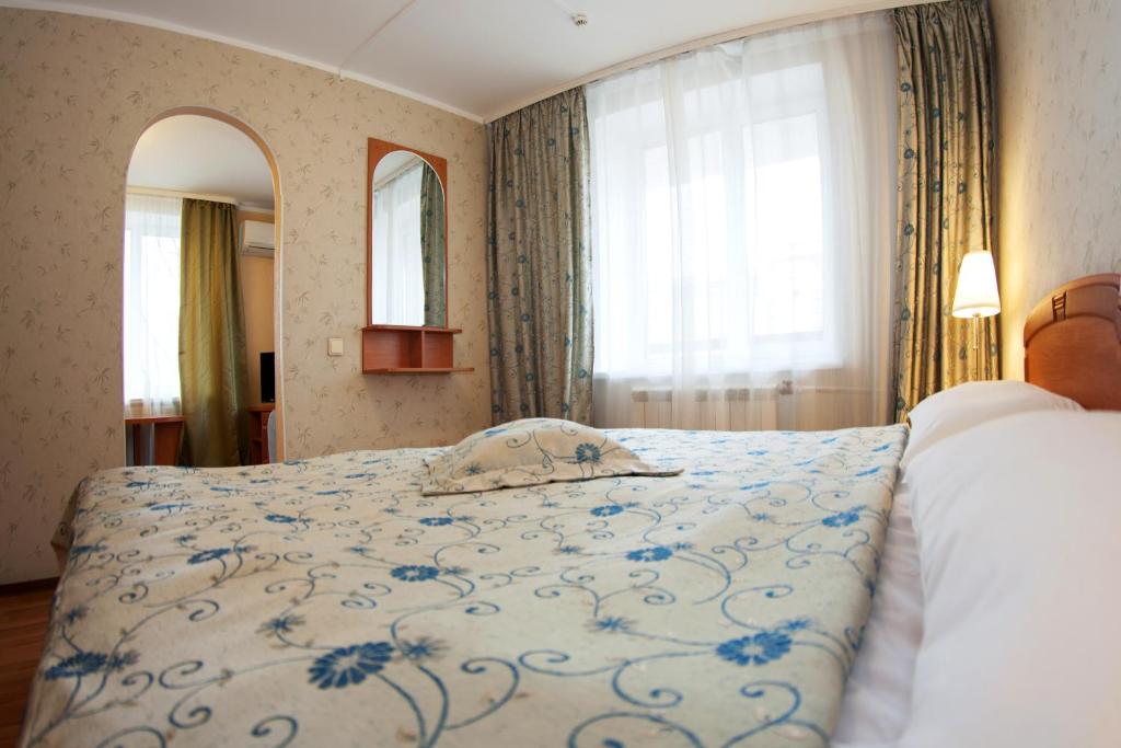 sypialnia z łóżkiem z niebiesko-białym kocem w obiekcie Kievskaya Hotel on Kurskaya w Petersburgu