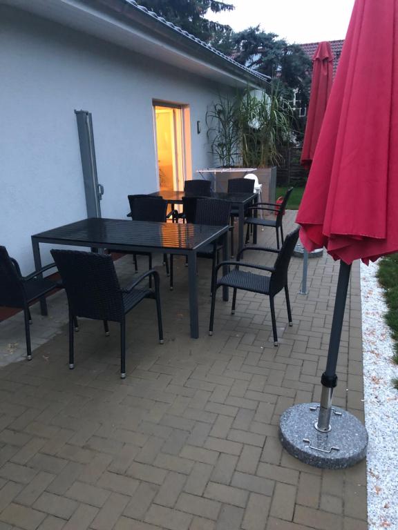 un patio con mesa, sillas y sombrilla rosa en Schilfblume, en Großkoschen