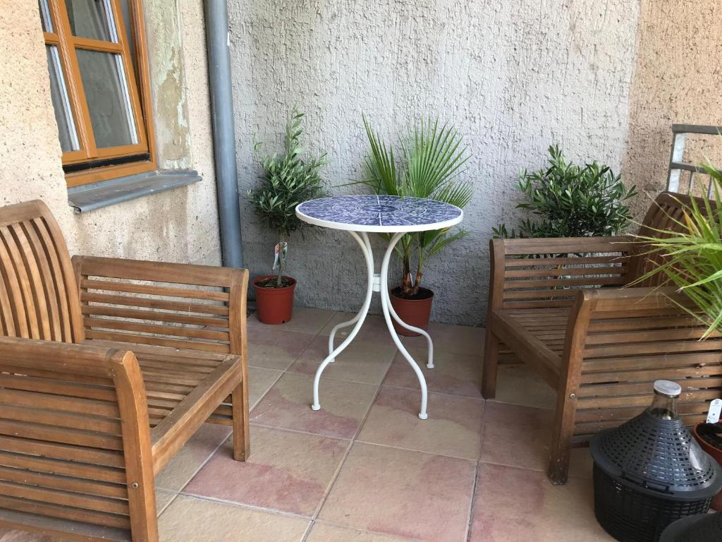 un patio con 2 bancos, una mesa y algunas plantas en Kleiner-Muldenblick en Leisnig