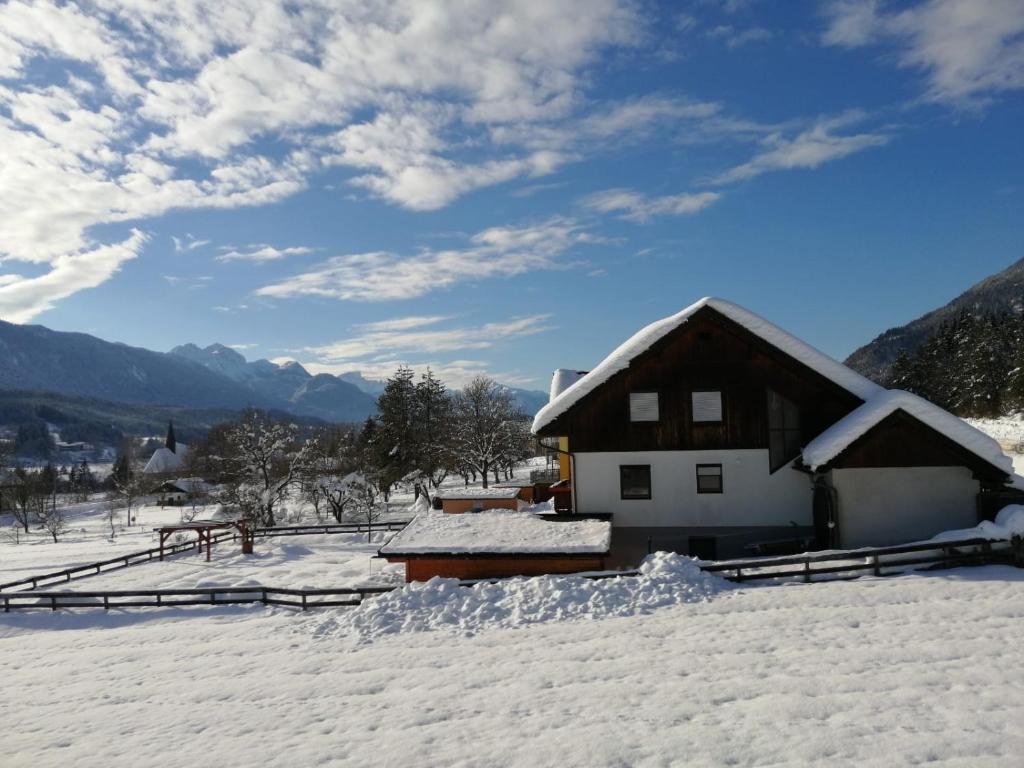 ein Haus ist mit Schnee bedeckt mit Bergen im Hintergrund in der Unterkunft Tom's Hütte in Presseggersee