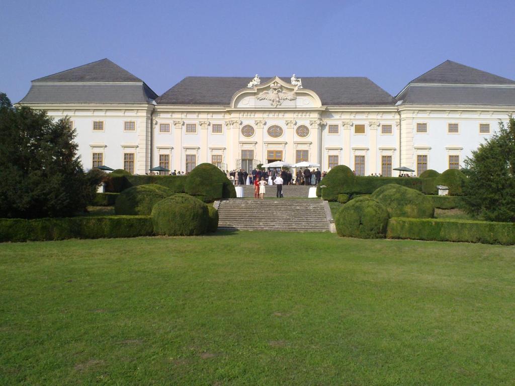 a large white building with a lawn in front of it at Knappenstöckl in Halbturn