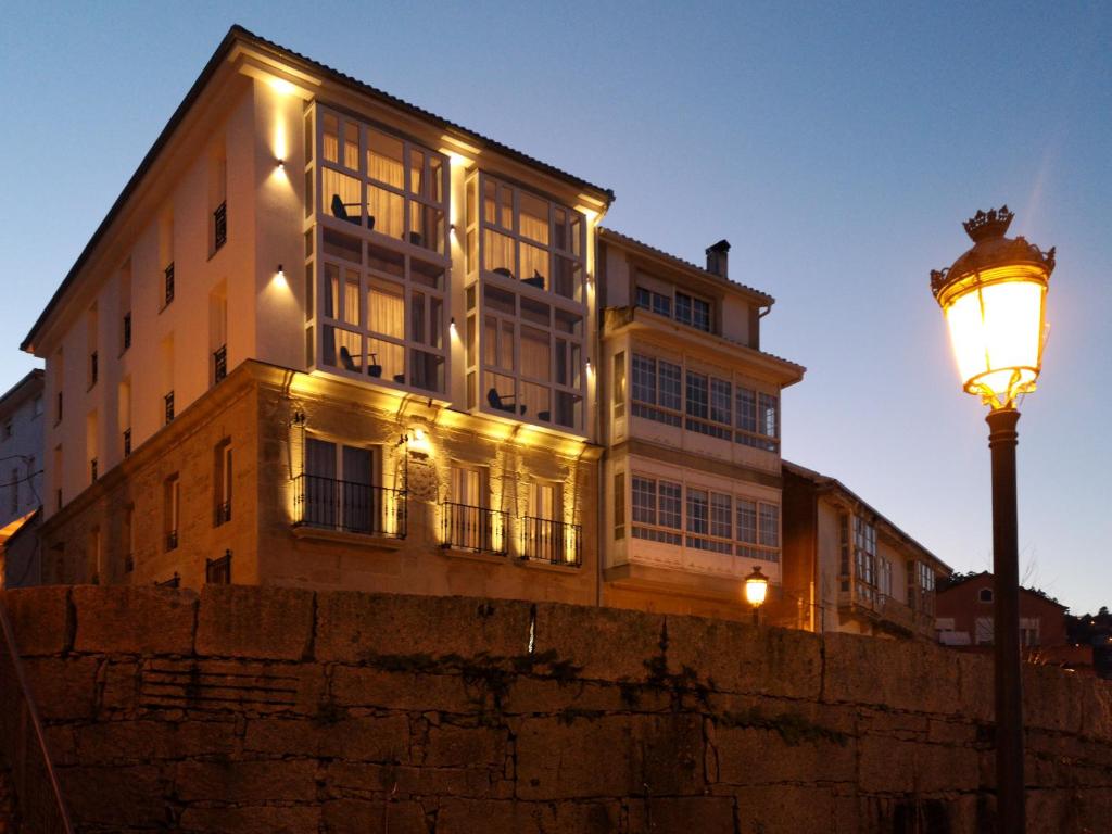 a building with a street light in front of it at Hotel do Porto in Muros
