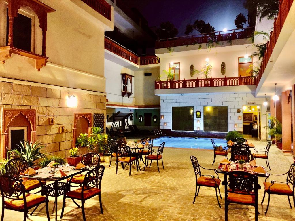 a restaurant with tables and chairs in a courtyard at Suryaa Villa - A Boutique Heritage Hotel in Jaipur