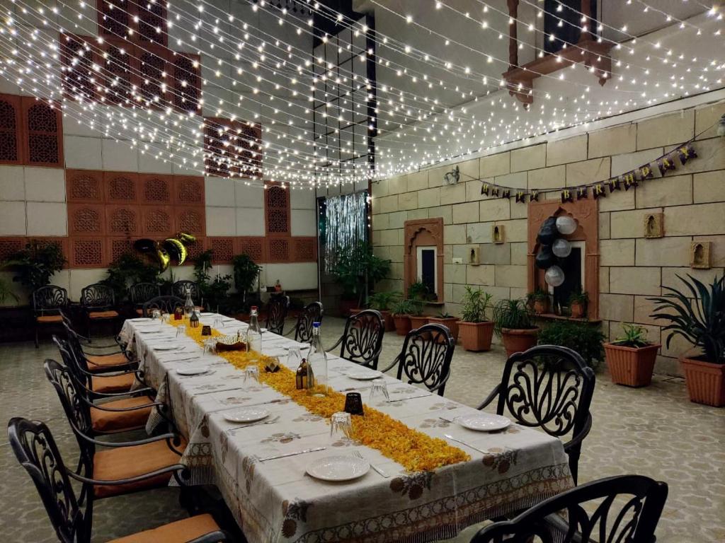 a long table in a room with chairs and lights at Suryaa Villa - A Boutique Heritage Hotel in Jaipur