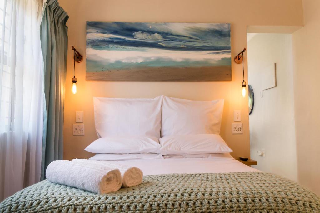 um quarto com uma cama com um quadro na parede em Mountain Glimpse em Paarl