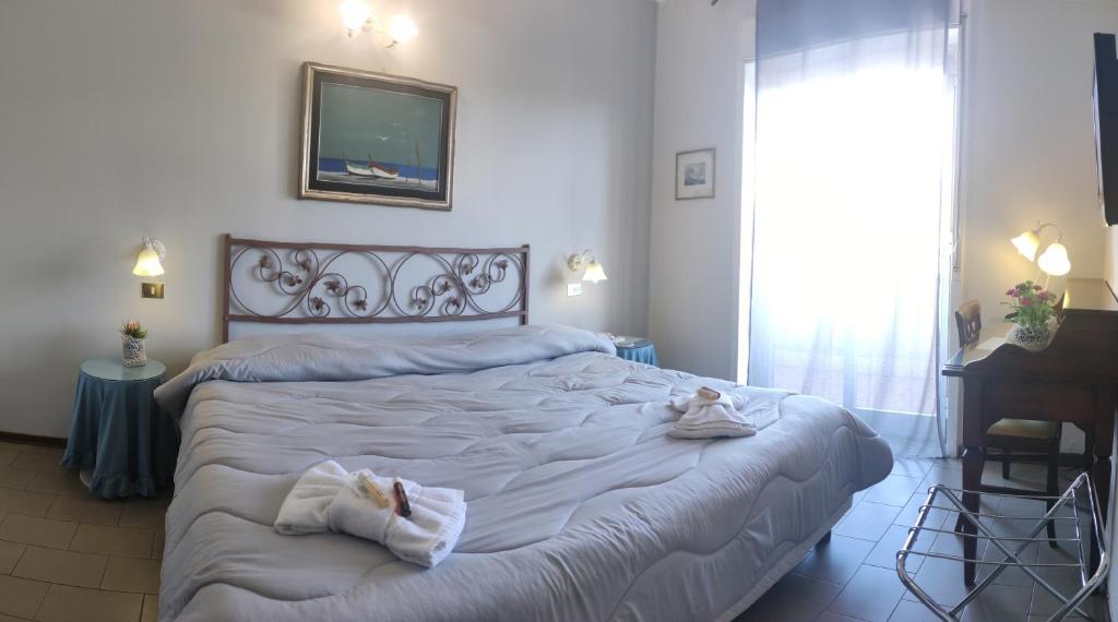una camera da letto con un grande letto con asciugamani di Ares Hotel a San Giovanni la Punta