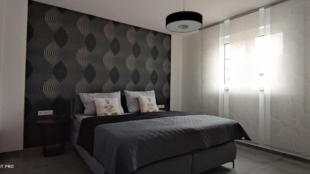 ein Schlafzimmer mit einem Bett und einer Wand in der Unterkunft Ferienwohnung Hesselberg in Balingen