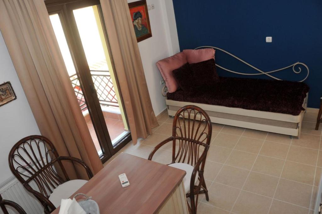 Dominique Rooms Meteora في كالامباكا: غرفة معيشة مع أريكة وطاولة وكراسي