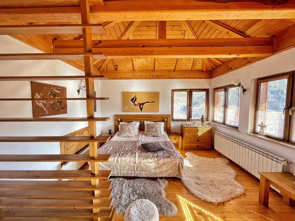 Un dormitorio con una cama grande en una habitación con techos de madera. en Rodope Nook Guest house en Chepelare