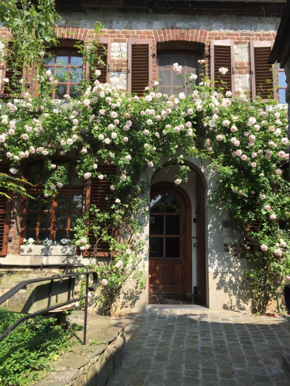 un edificio con un montón de rosas sobre una puerta en Le Chénia, en Wanze