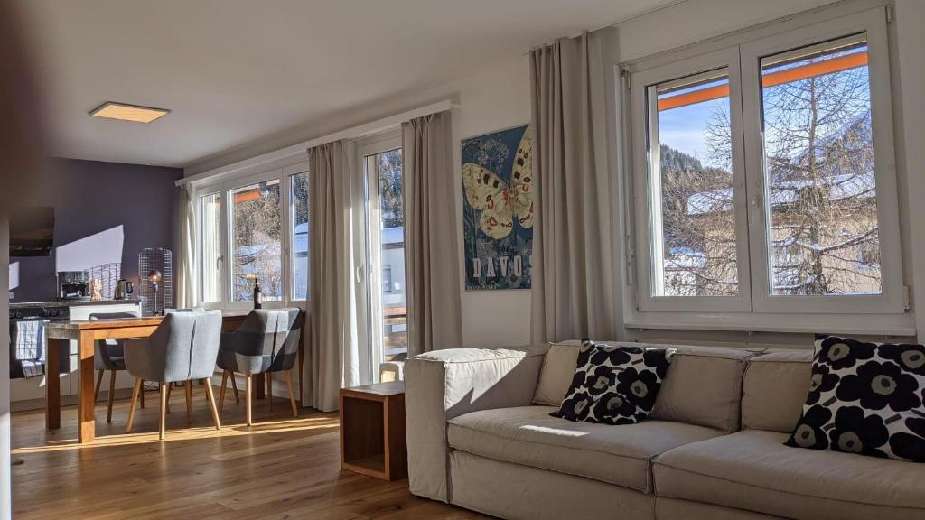 ein Wohnzimmer mit einem Sofa und einem Esszimmer in der Unterkunft Ferienwohnung Parsennblick mit Dachterrasse in Davos