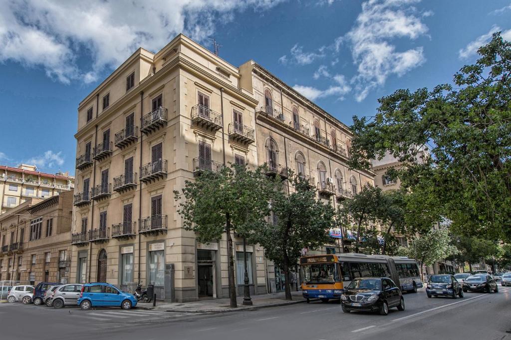 um edifício numa rua com carros estacionados em frente em Artemisia Palace Hotel em Palermo
