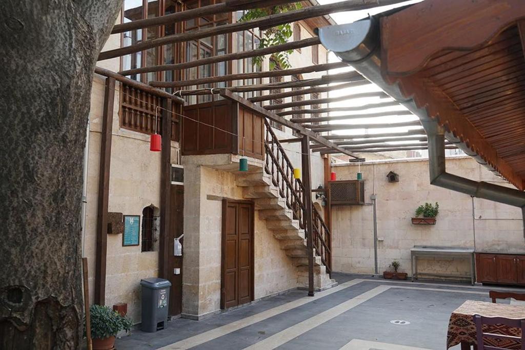 a building with a wooden staircase in a courtyard at Beliz Hanım Konakları in Gaziantep