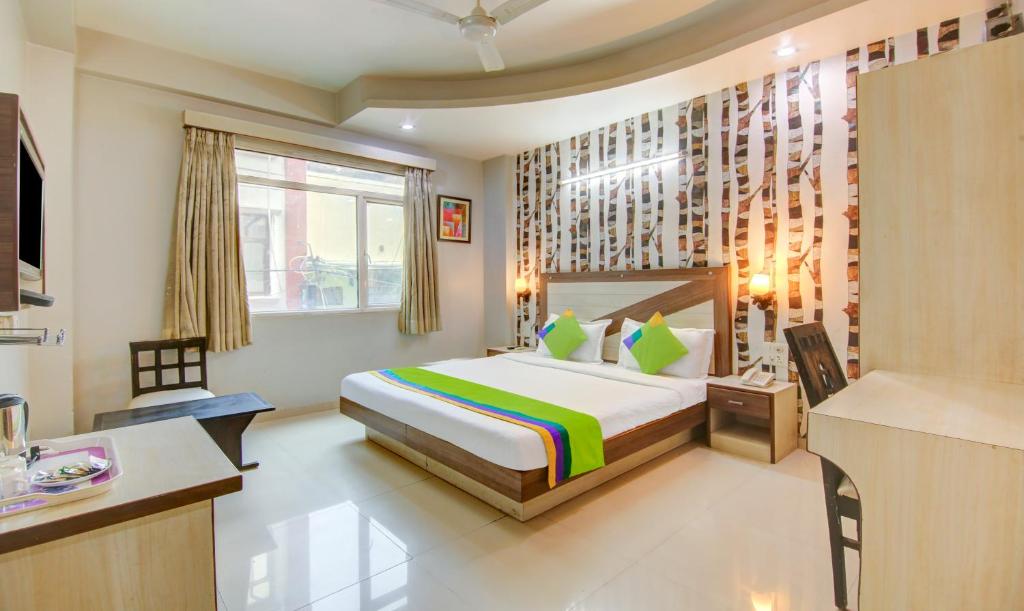 a hotel room with a bed and a kitchen at Treebo Trend Rockwell Plaza in New Delhi