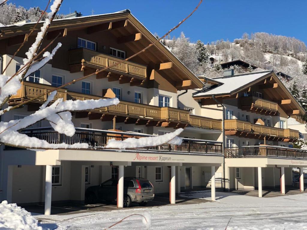 a large building with a car parked in front of it at AlpinResort Kaprun 2 in Kaprun