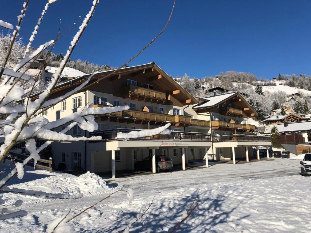 a large building in the snow with a parking lot at AlpinResort Kaprun 11 in Kaprun