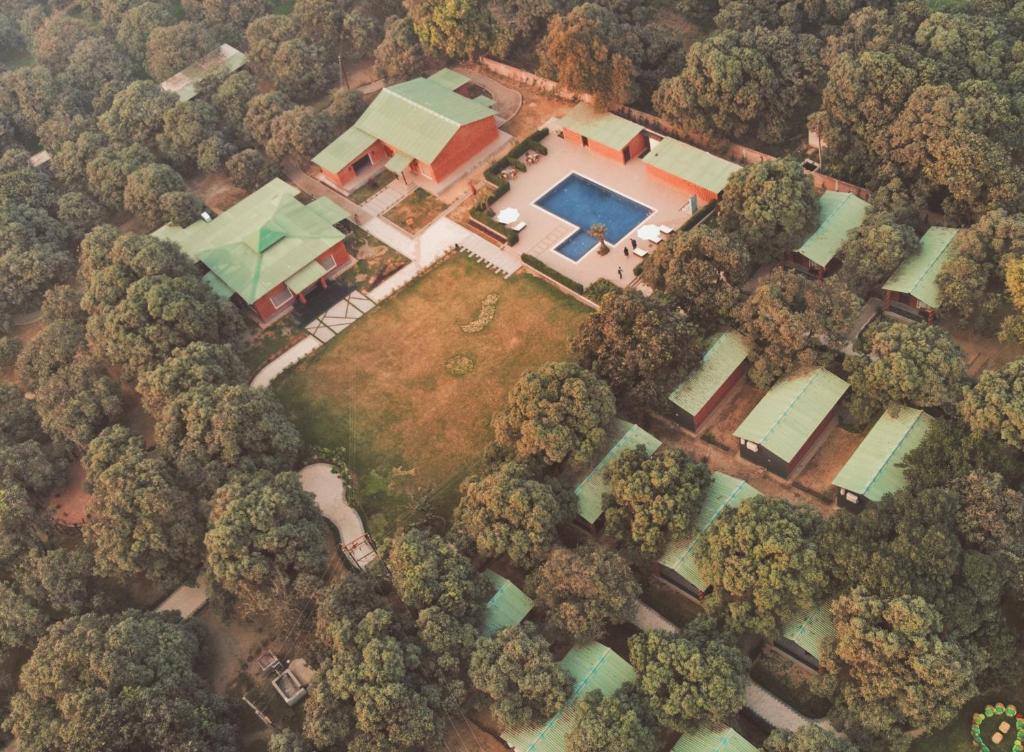 an aerial view of a house with a swimming pool and trees at MANGO TREE RESORTS in Siyāna