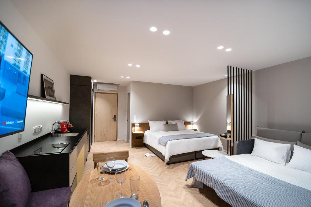 um quarto de hotel com duas camas e uma televisão de ecrã plano em Alinea Suites Limassol Center em Limassol