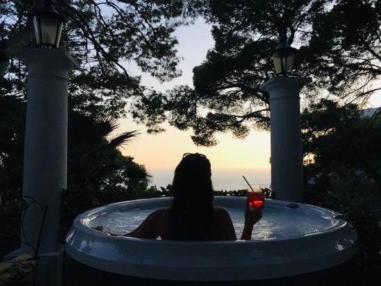 uma mulher sentada numa banheira com um telemóvel em Villacore Luxury Guest House em Capri