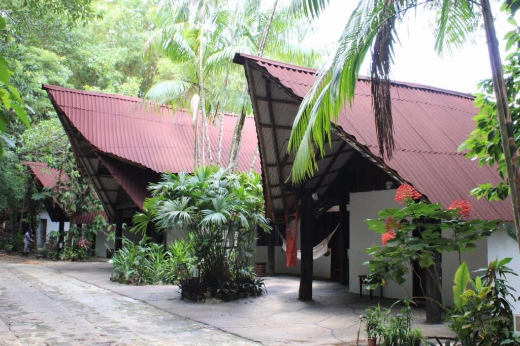 a building with a red roof and some plants at ReservAmazon Forest Hotel in Belém