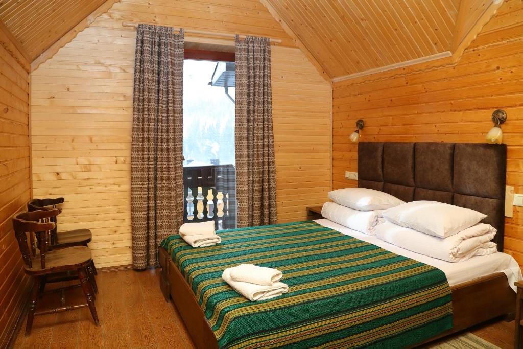 Un dormitorio con una cama con toallas. en Гук готельно-ресторанний комплекс, en Bukovel
