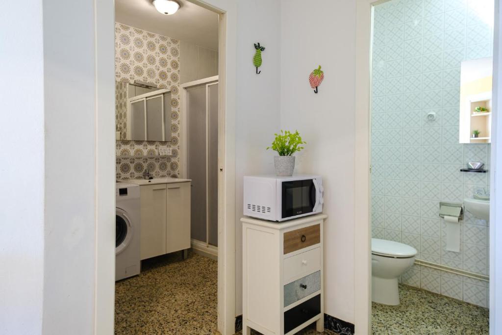 a bathroom with a toilet and a microwave on a counter at Apartamentos Deauville in Miami Platja