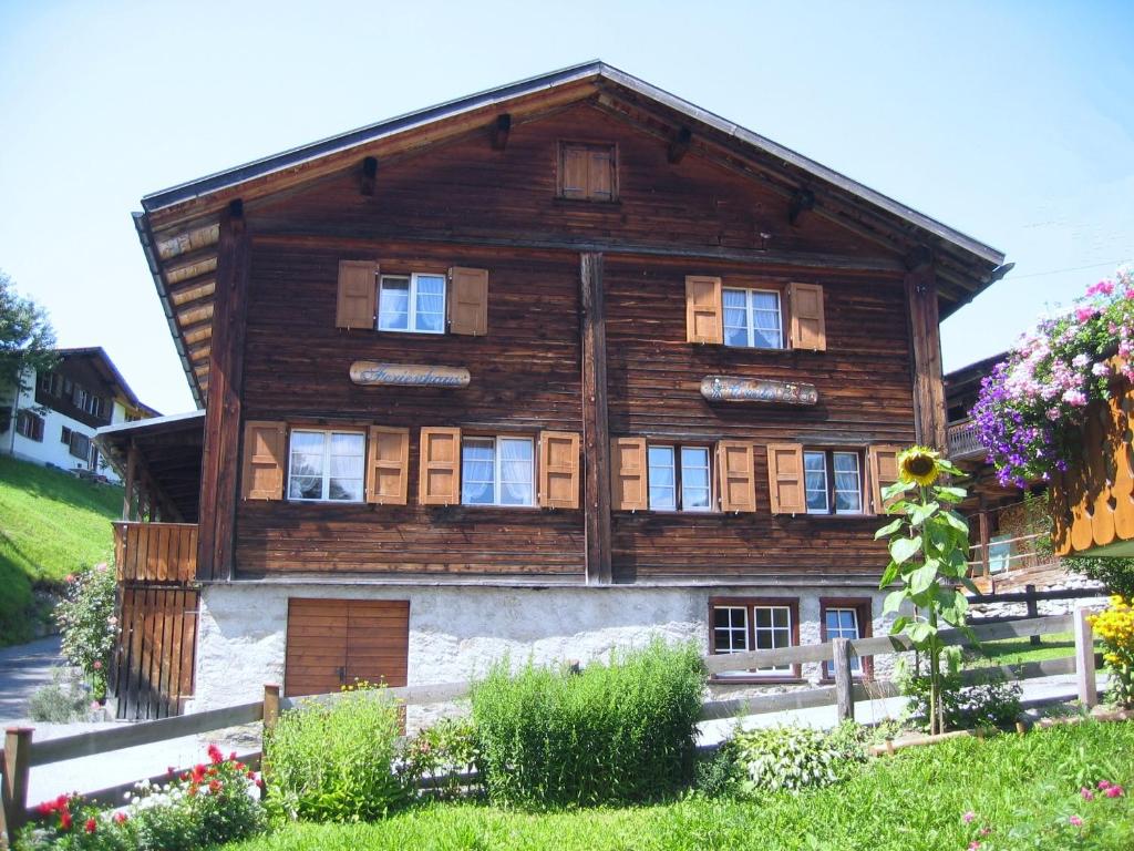 een houten huis met een hek ervoor bij Cresta - 9,5-Zimmerhaus für 19 - 20 Personen, 270m2 in Conters