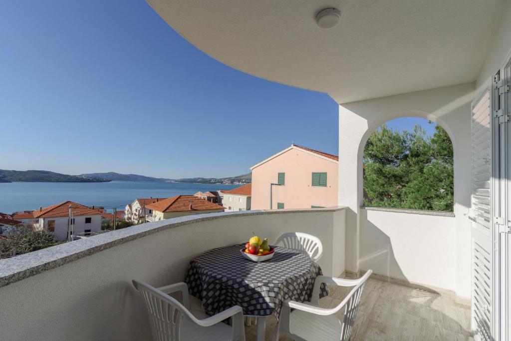 a balcony with a table and chairs and a view of the water at Villa Anđelo in Trogir