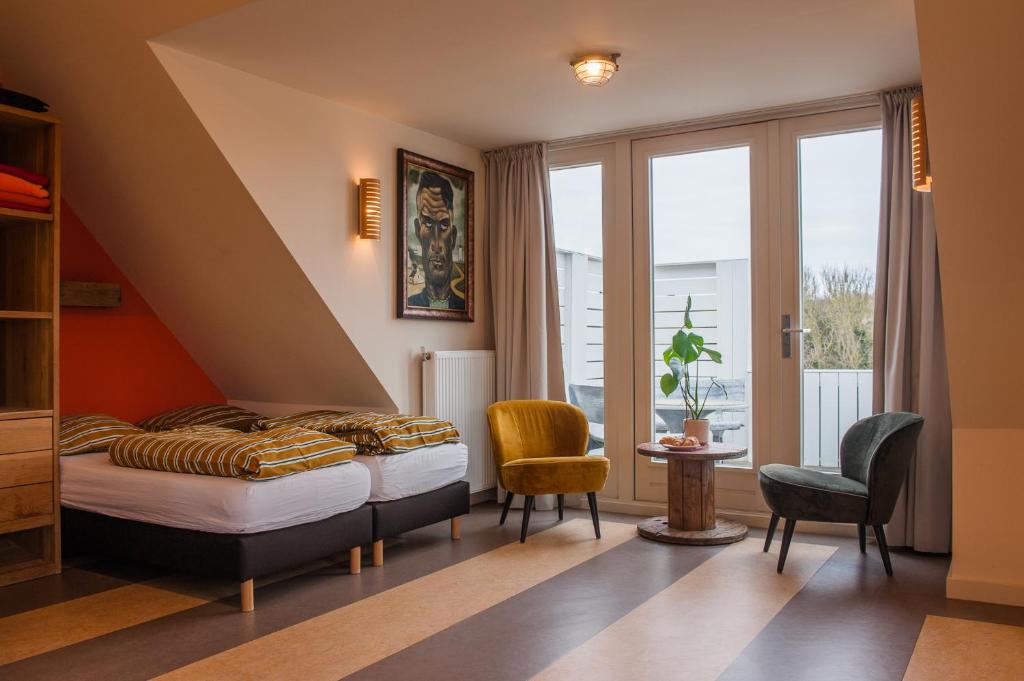 een slaapkamer met een bed en een raam bij Studio aan Zee in Westkapelle