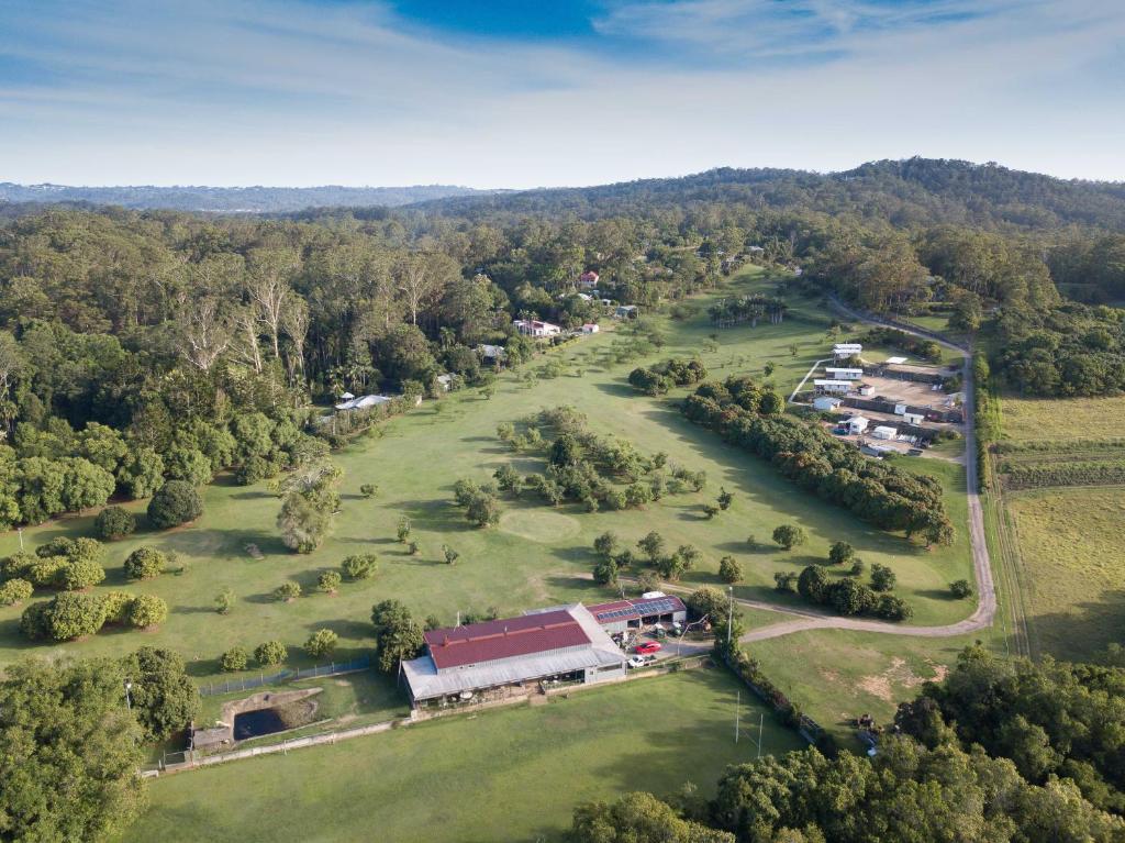 an aerial view of a park with a barn and trees at Sunshine Coast retreat your own private golf course in Diddillibah