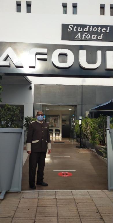 a man wearing a mask standing in front of a building at Studiotel Afoud in Agadir