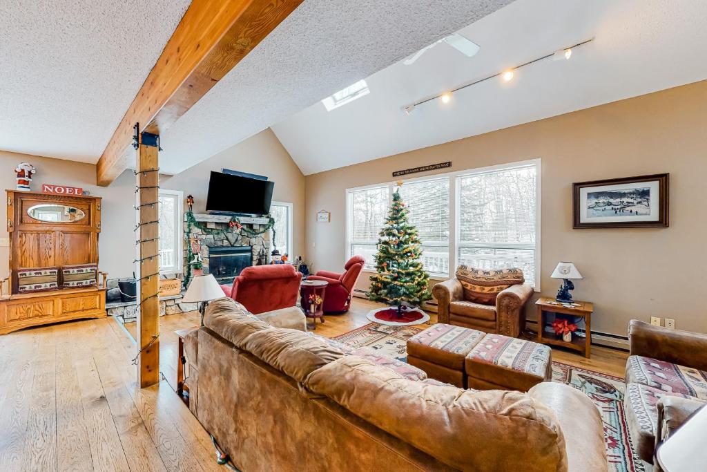 een woonkamer met een bank en een kerstboom bij 13 Oak Ridge Road in Madison