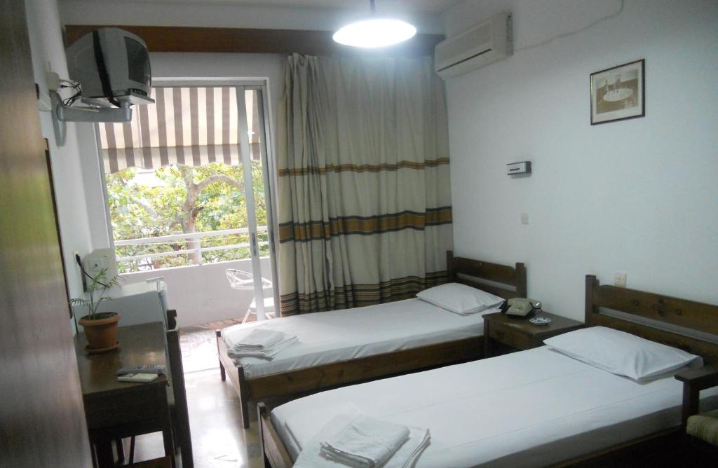 a hotel room with two beds and a window at Rex Chasioti in Loutra Ipatis