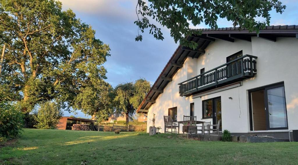 uma casa com uma varanda ao lado em Aux Capucines em Theux